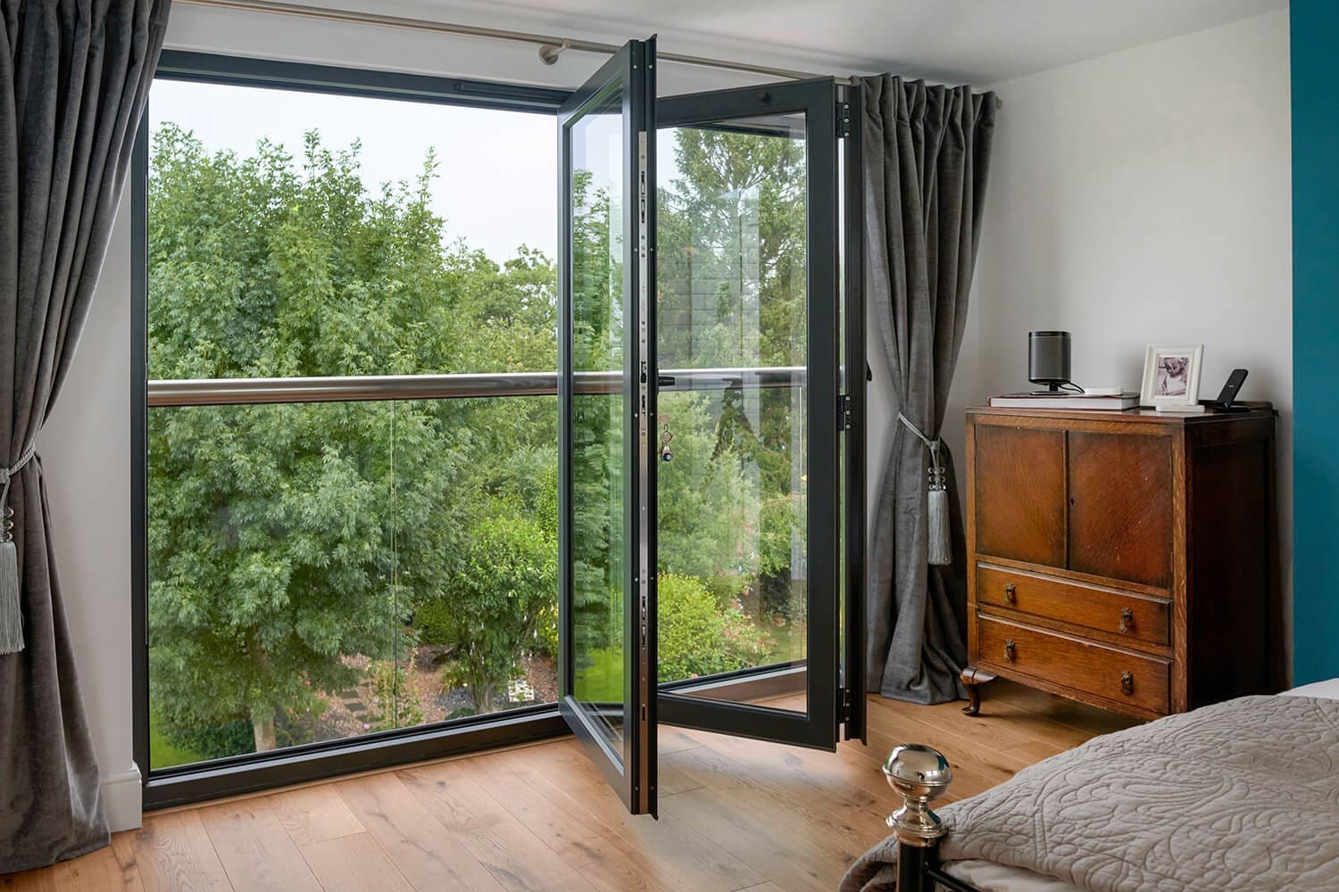 bi-fold doors with glass balcony overlooking garden space