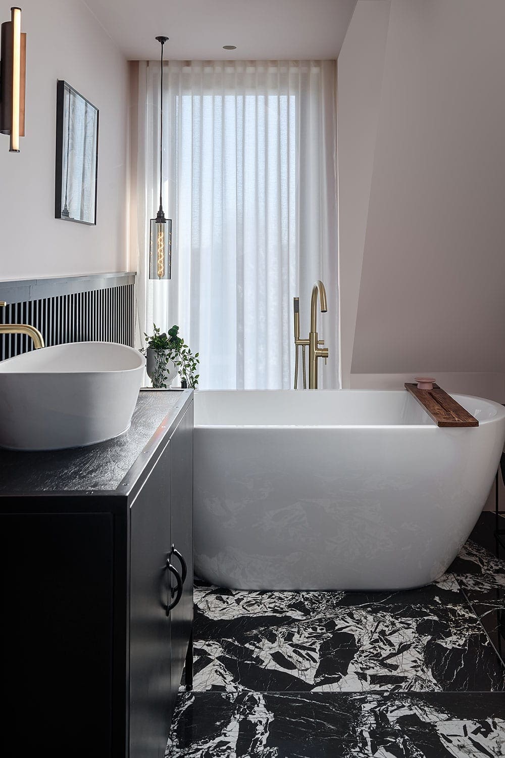 modern hip-to-gable loft conversion with a black marble floor and a stylish sink and freestanding bathtub