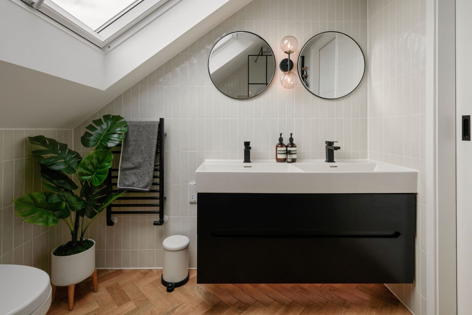 loft conversion bathroom with twin sinks and pitched ceiling