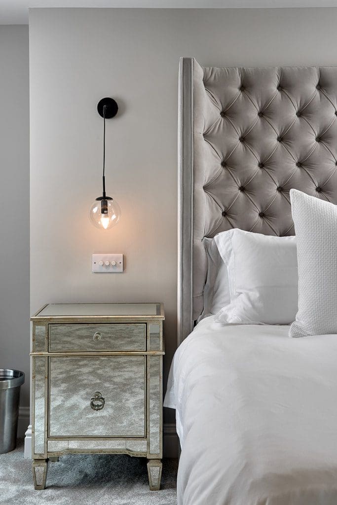 l-shaped dormer loft conversion with luxury bed and bedside table