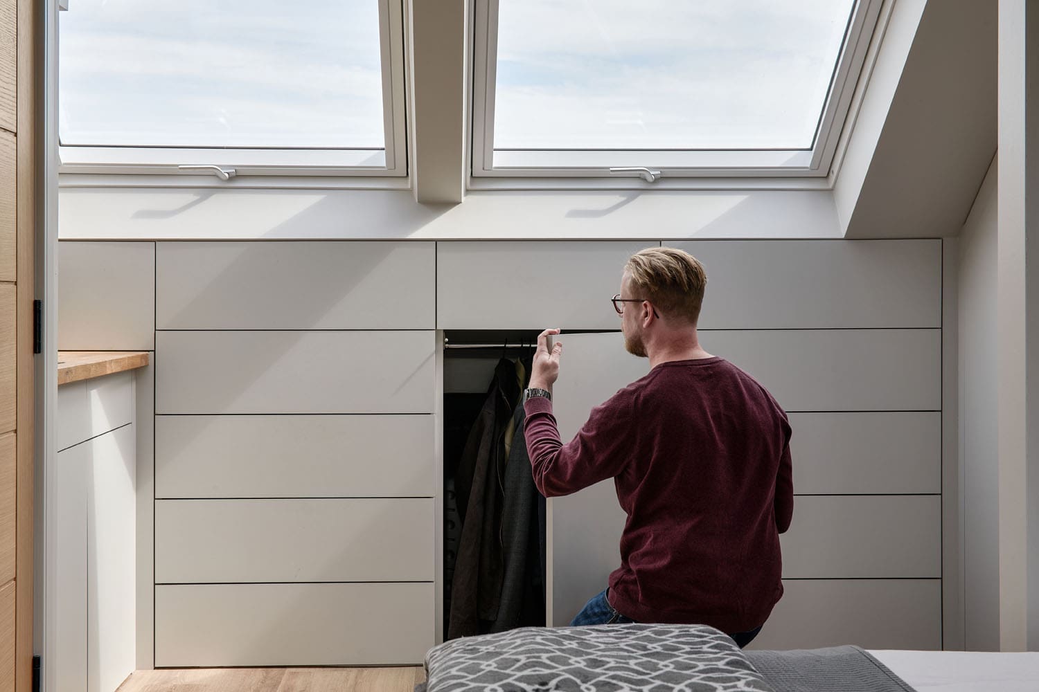 man looking in closet storage of dormer loft conversion