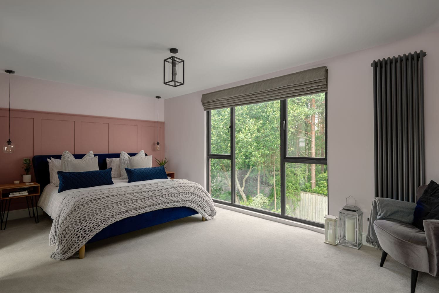 large master bedroom loft with bifold windows, pink wall paneling, and double bed