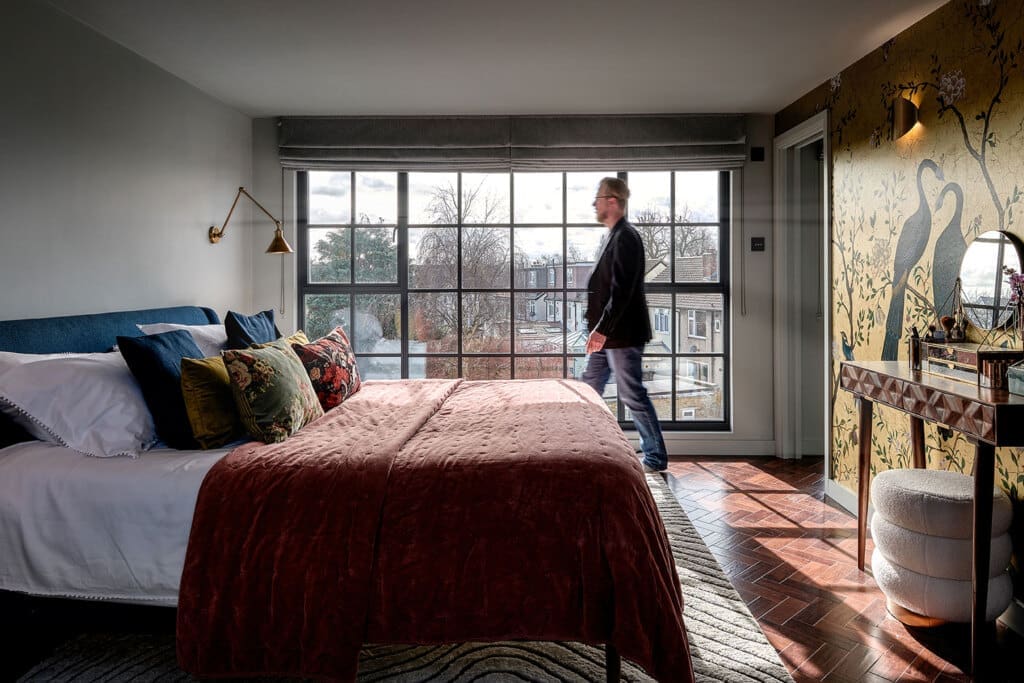 man walking across loft conversion in front of dormer windows